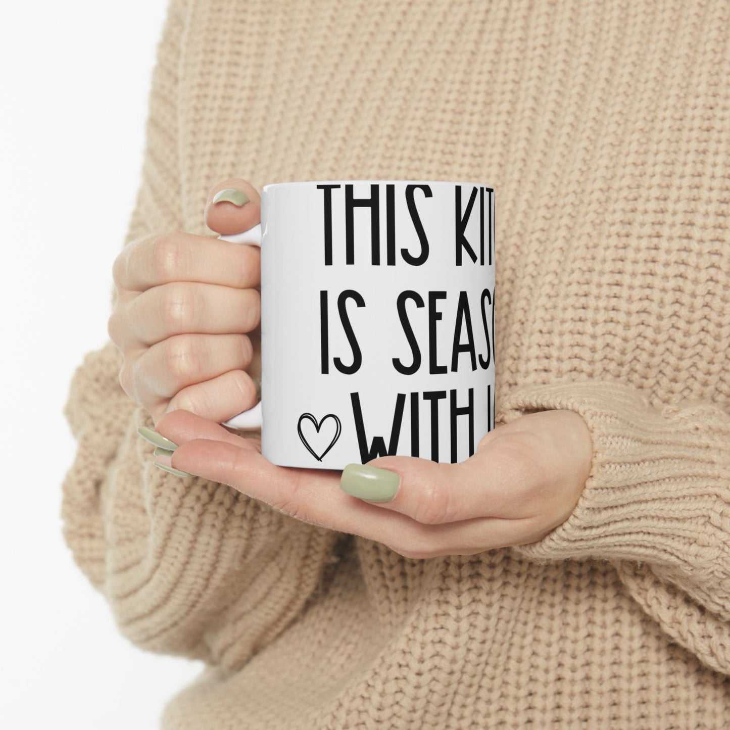White mug with black text "THIS KITCHEN IS SEASONED WITH LOVE" and a heart.