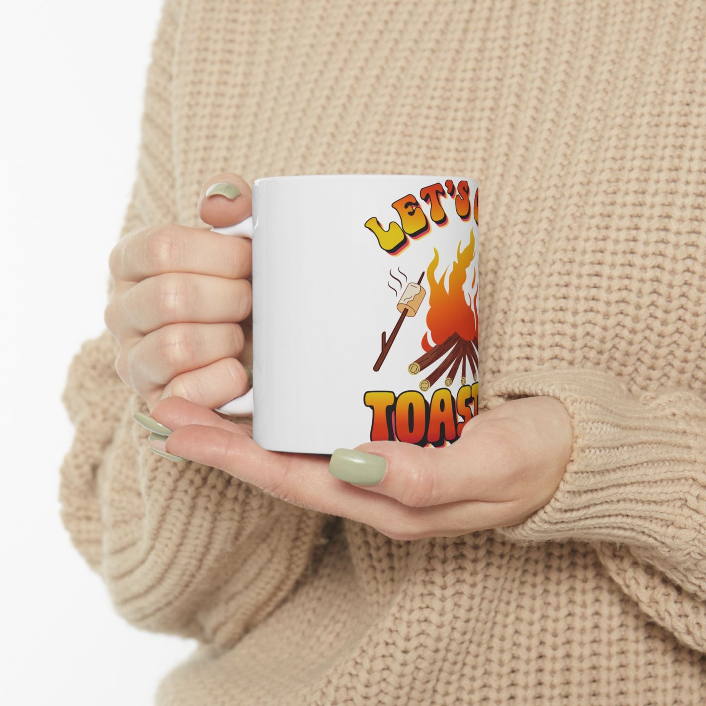 Mug with "Let's Toast" and a marshmallow on a stick over flames.