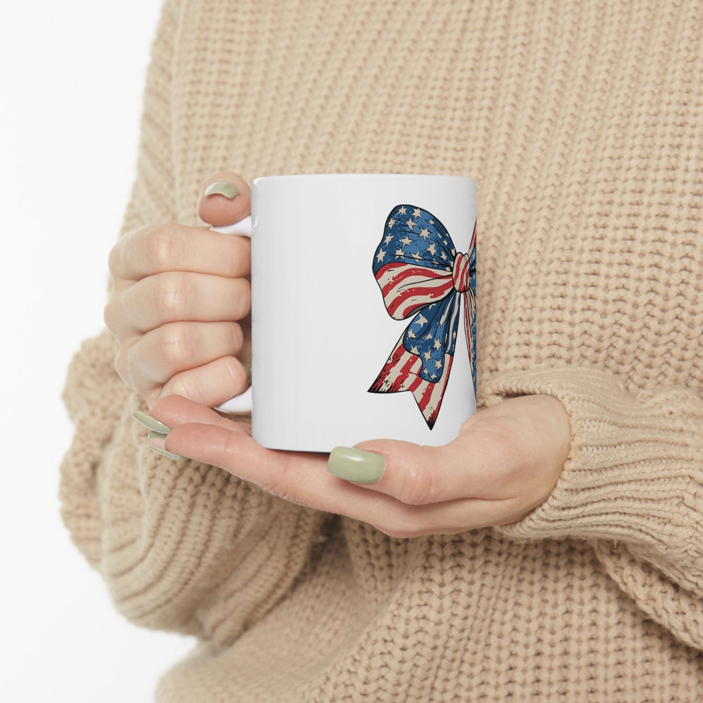 White mug with an American flag ribbon design held by hands.