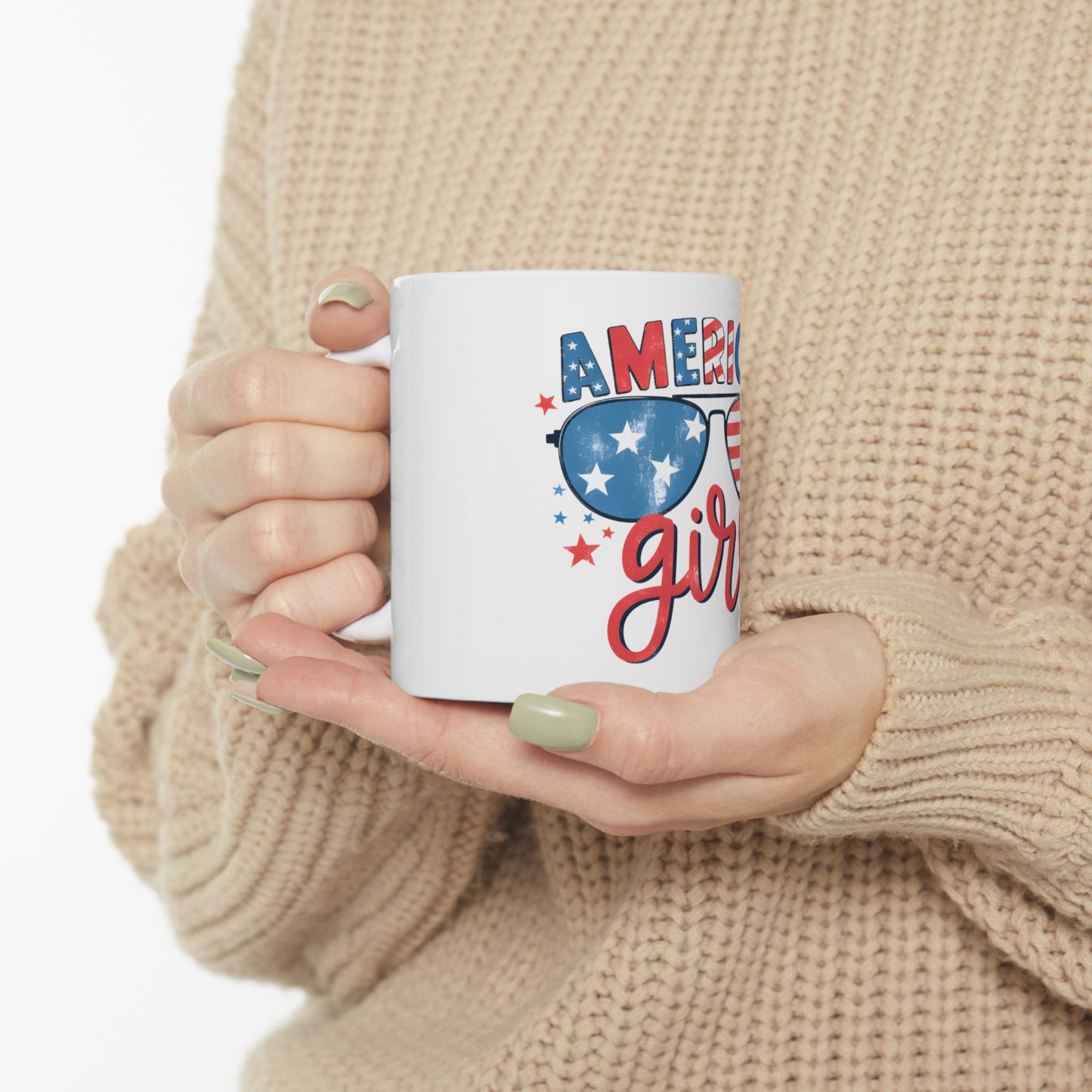 White mug with "Ameri girl" and sunglasses graphic held by hands.