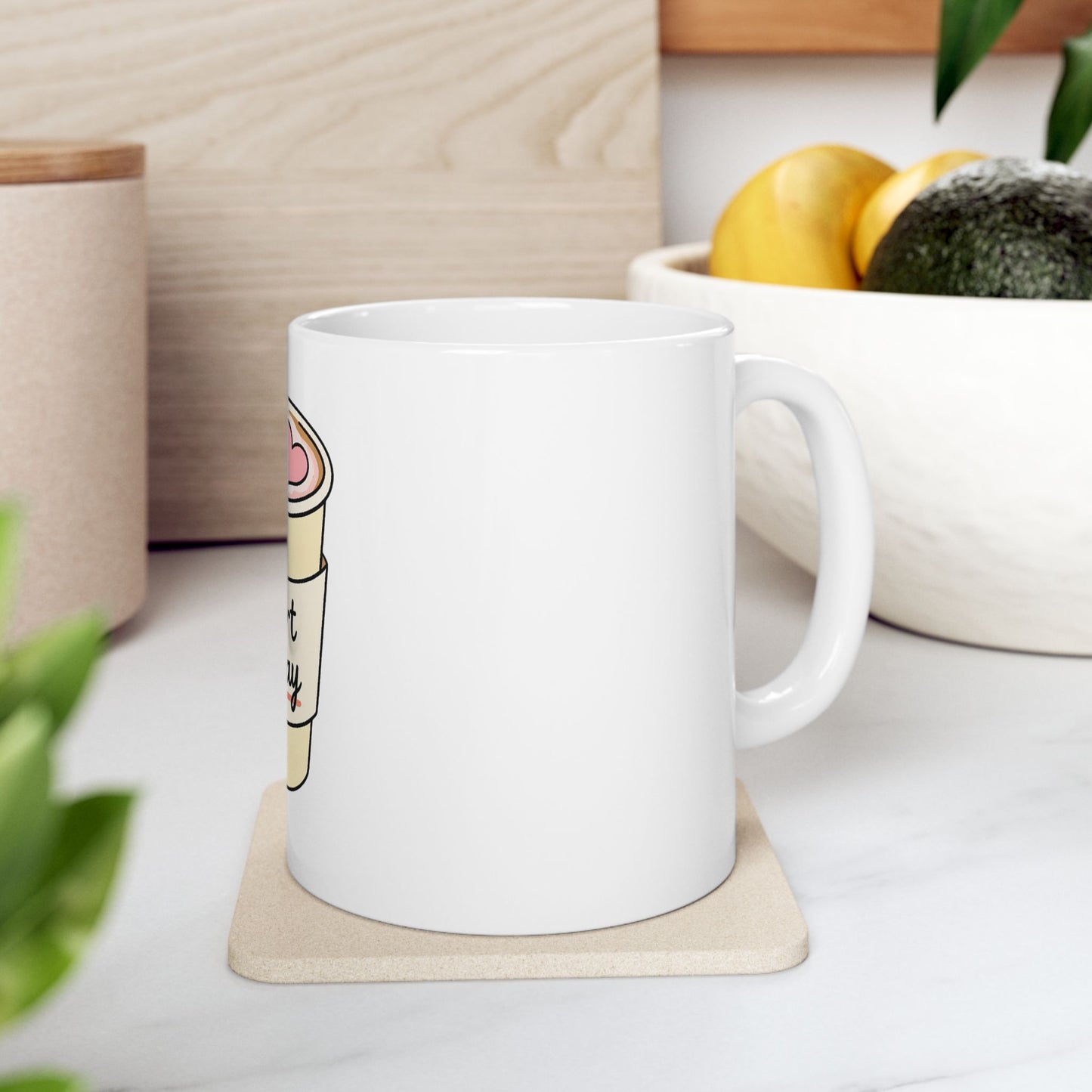 White mug with "But First Coffee" label on a coaster.