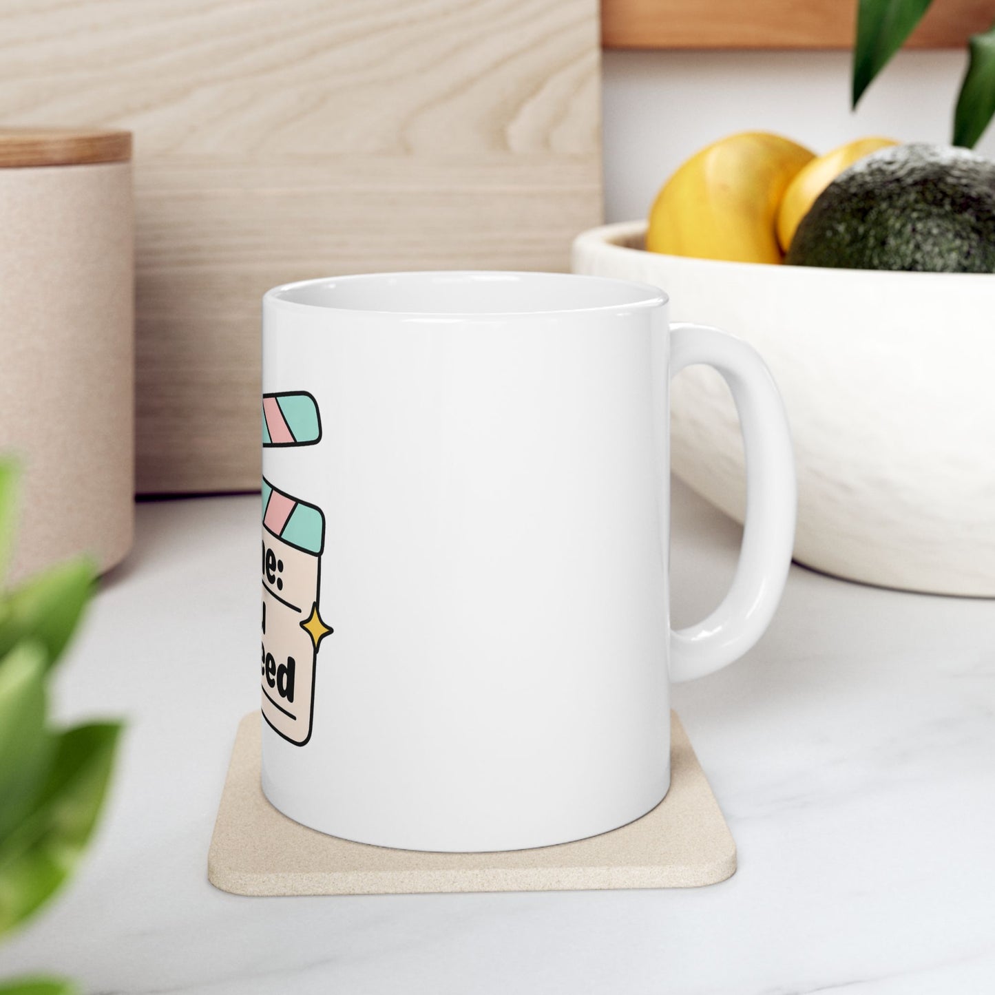 White mug with "Scene: All I need" text on a coaster.