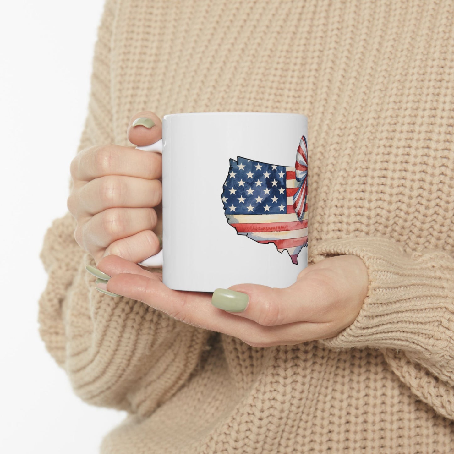White mug with US map outline, American flag, and red bow detail.