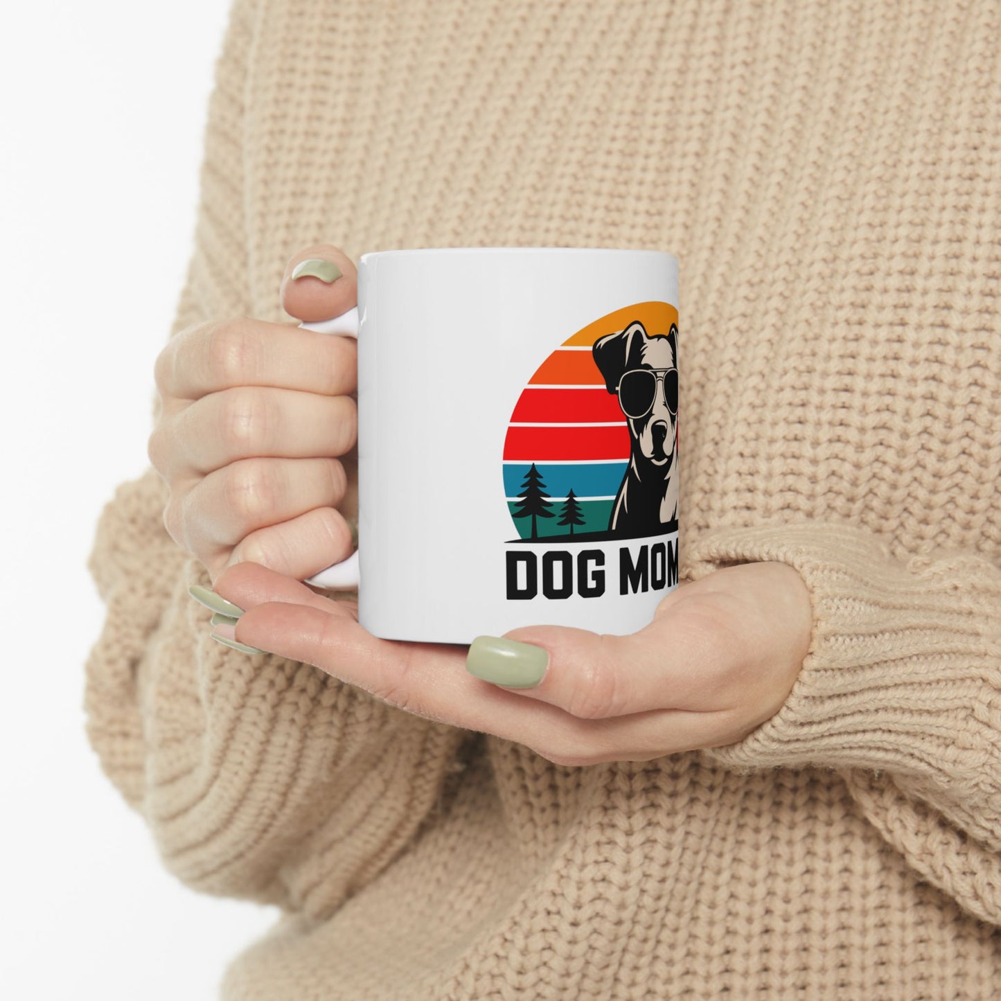 White mug with "DOG MOM" text and dog silhouette in sunset circle.