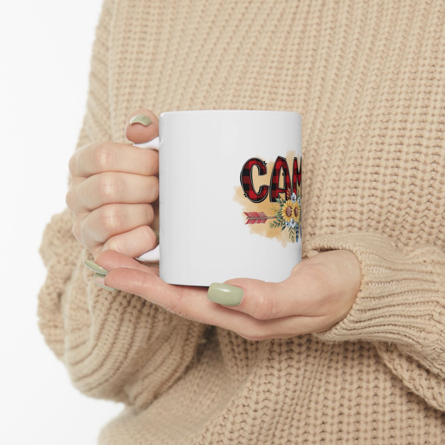 White mug with "CAMP" in colorful letters and floral accents.