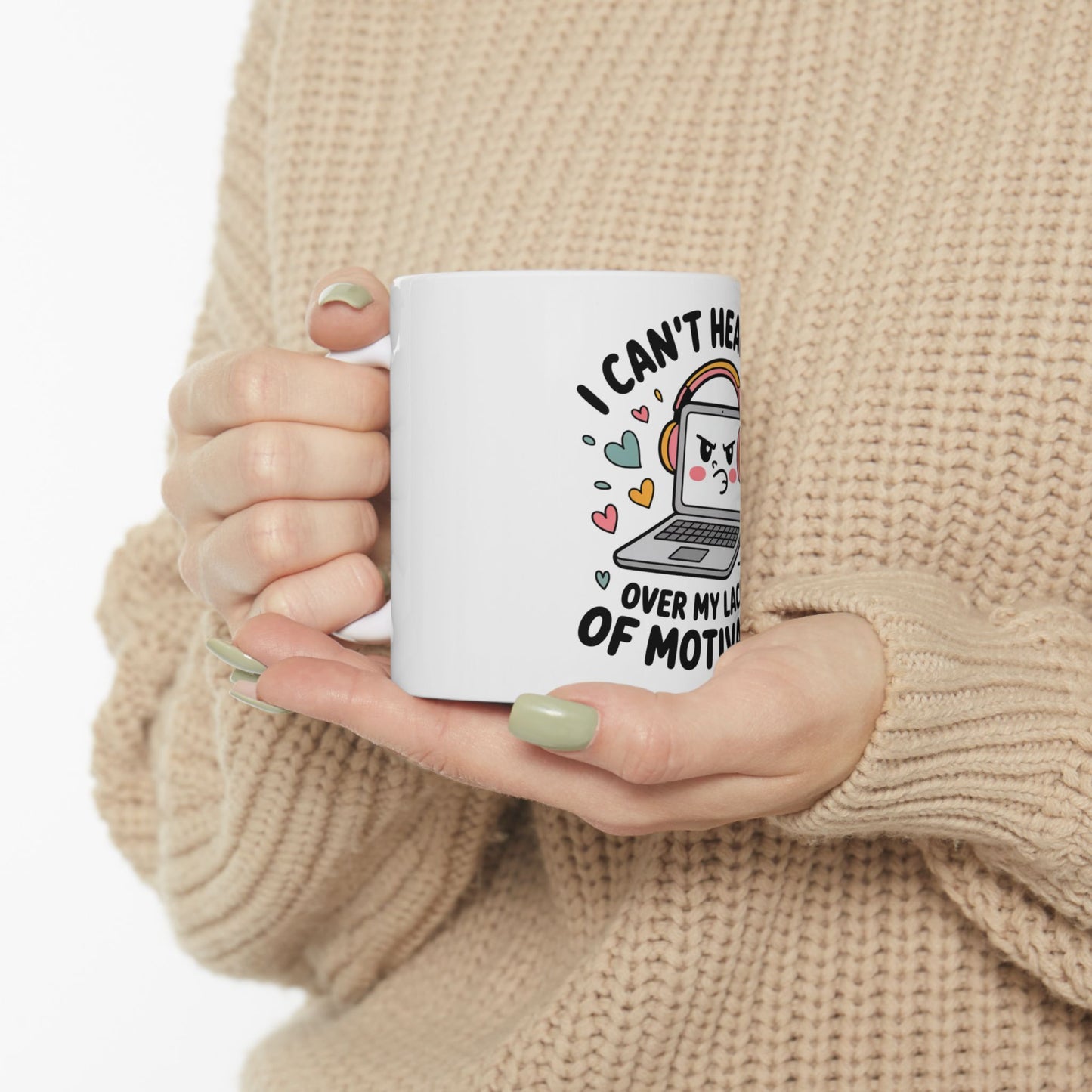 White mug with cartoon headphones and laptop, reading "I CAN'T HEAR YOU OVER MY LACK OF MOTIVATION".