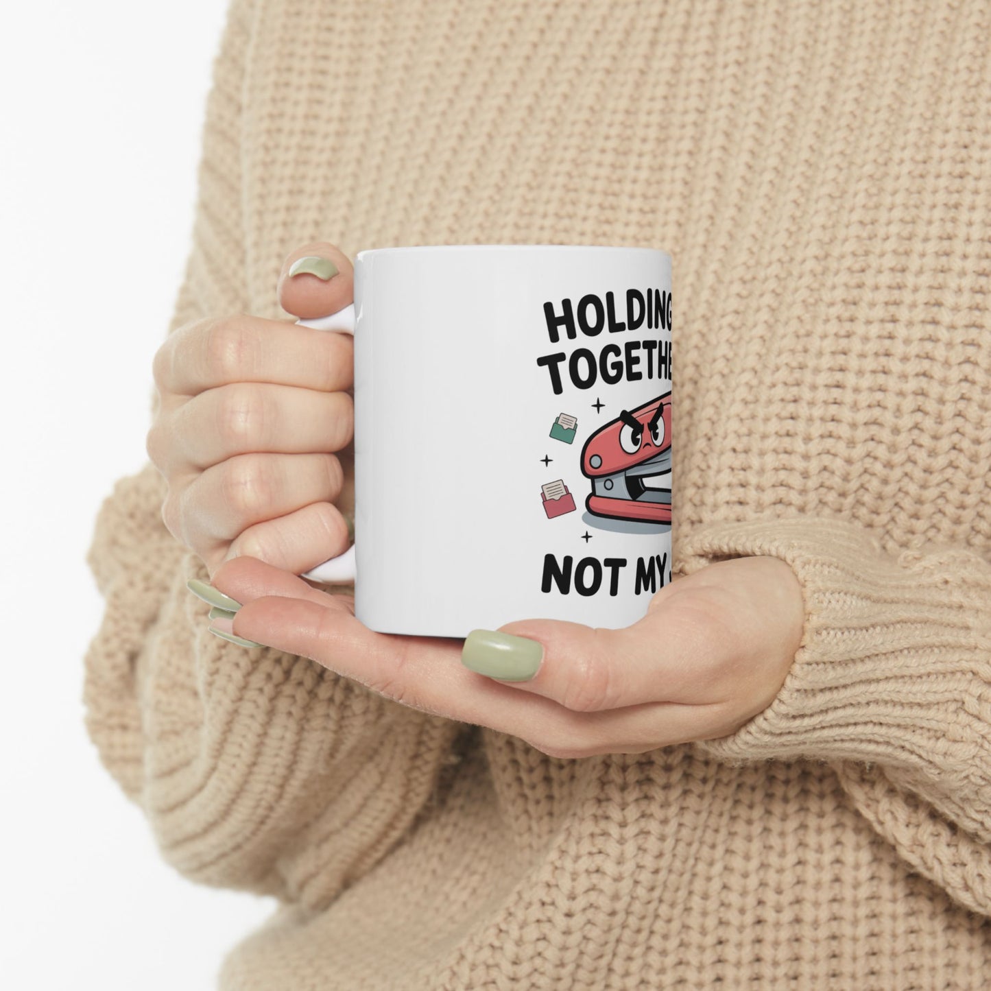 White mug with a stapler character saying "HOLDING TOGETHER NOT MY".