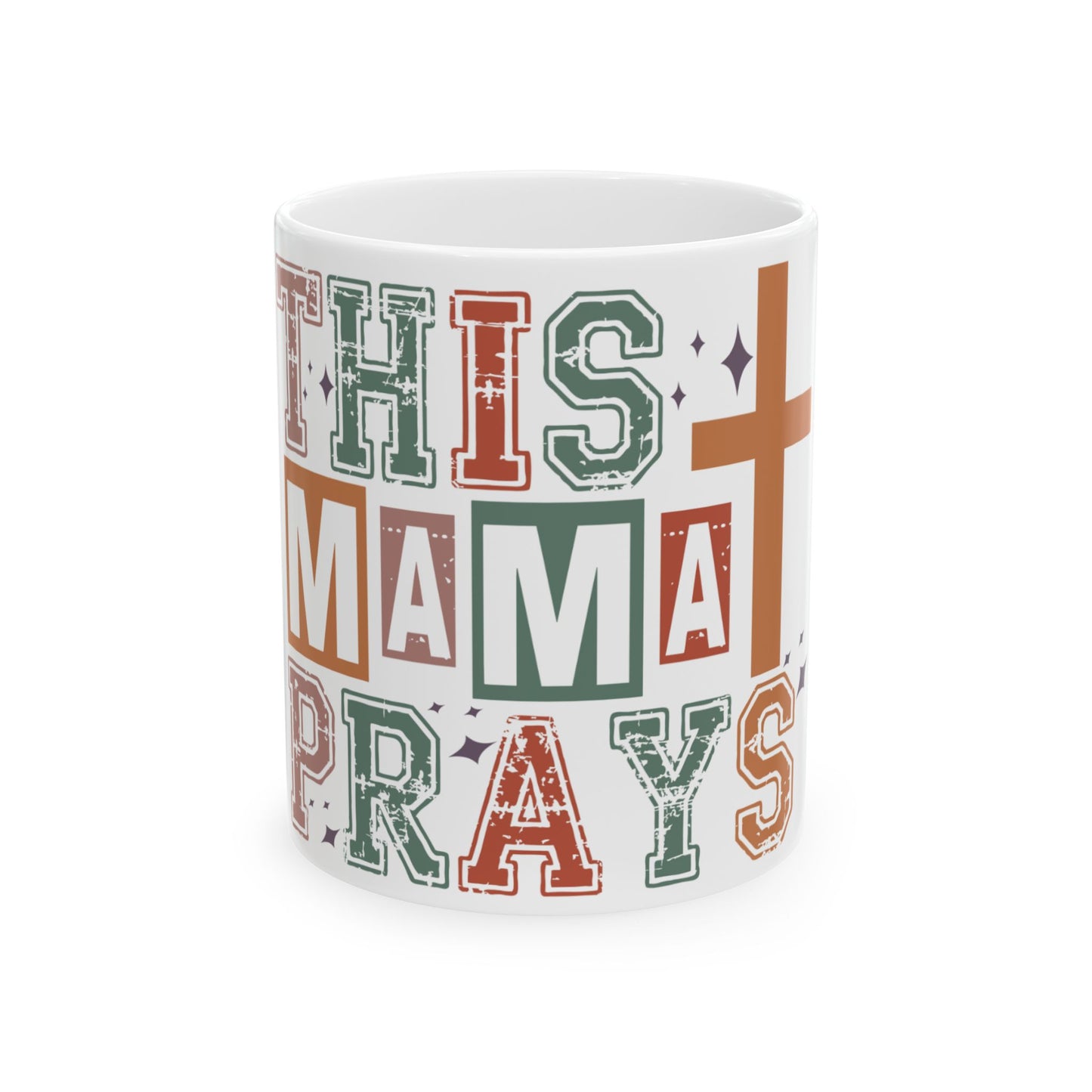 White mug with colorful text reading "THIS MAMA PRAYS" and a cross.