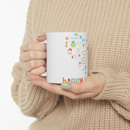 White mug with colorful outdoor icons and "happy camper" text.