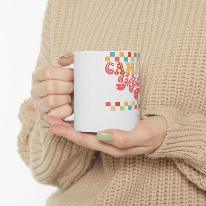 White mug with colorful "CAMP MOM" text and pixelated squares.