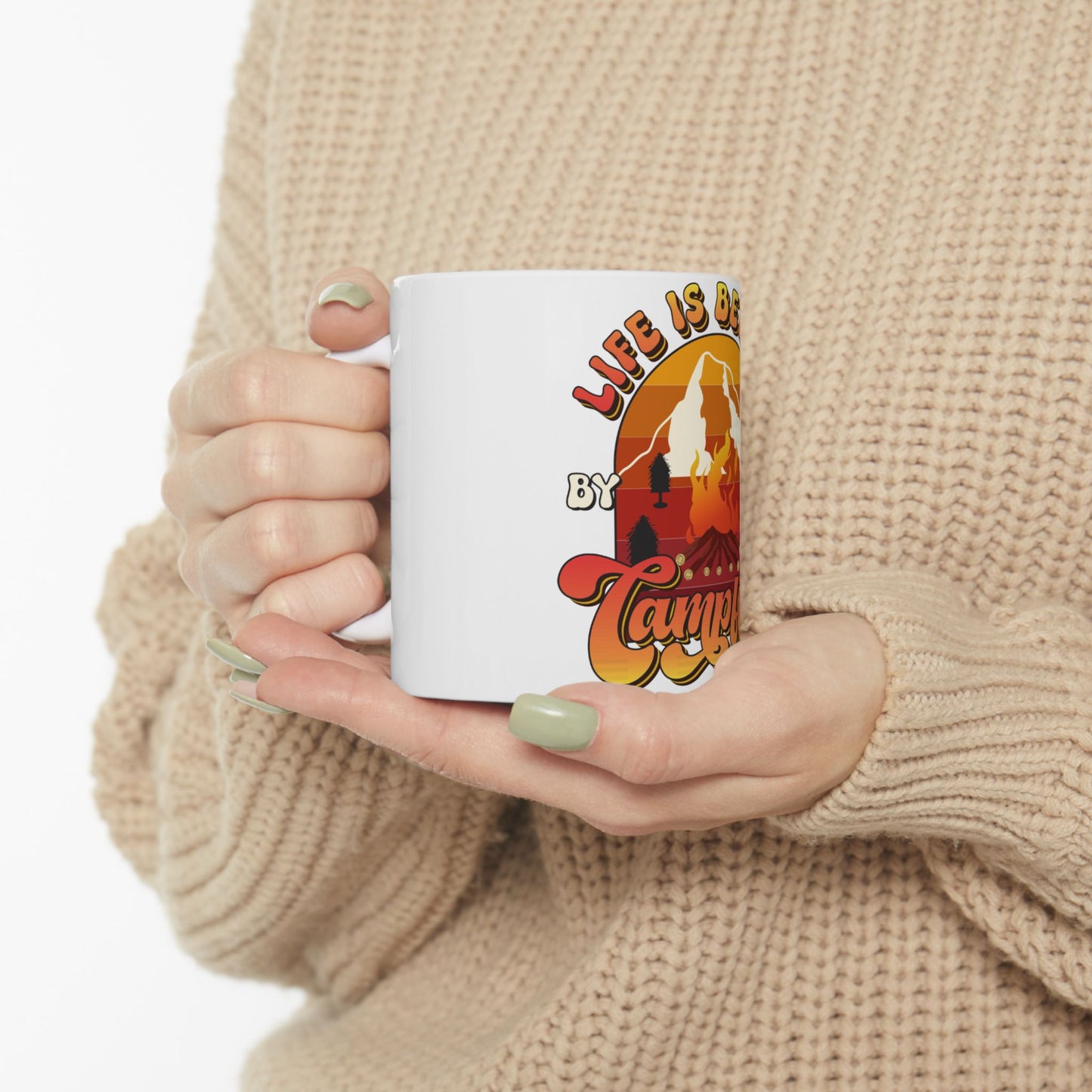 White mug with "Life is Better by Camping" text and a mountain sunset design.