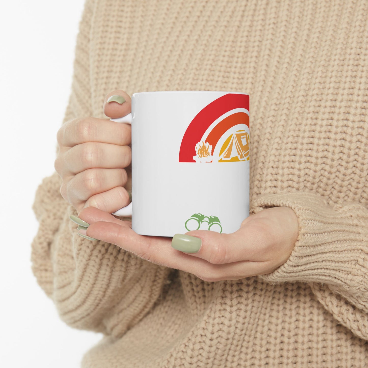 White mug with camping graphics: rainbow, tent, campfire, binoculars.