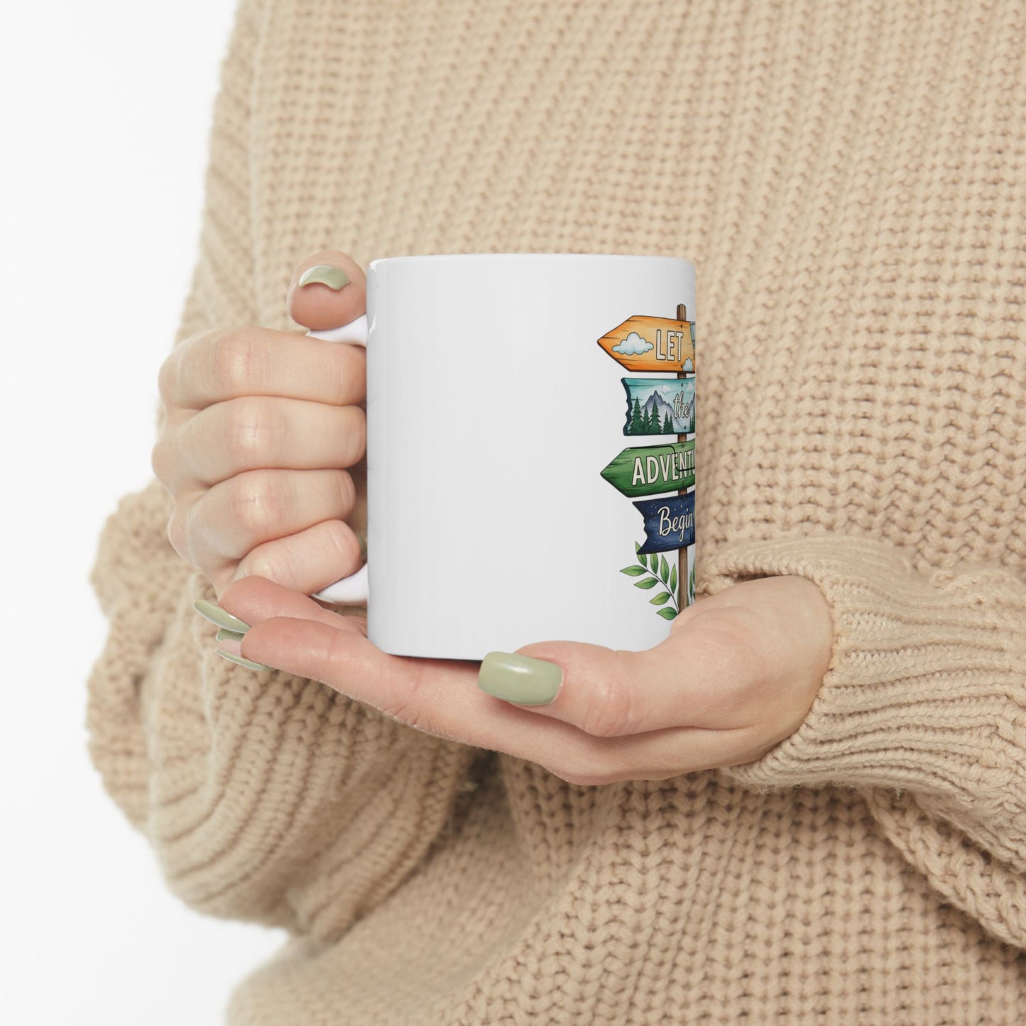 White mug with directional signs saying "Let the adventure begin".