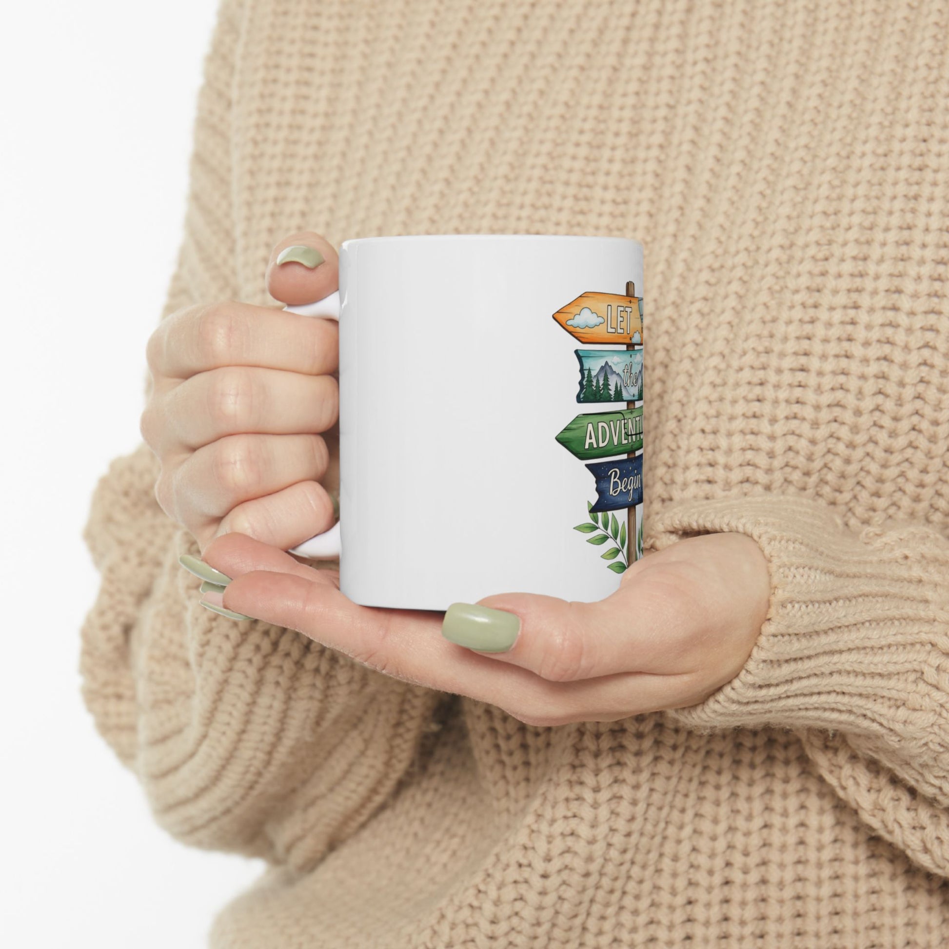 White mug with directional signs saying "Let the adventure begin".