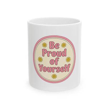 White mug with pink circle and yellow flowers, text "Be Proud of Yourself".
