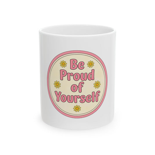 White mug with pink circle and yellow flowers, text "Be Proud of Yourself".