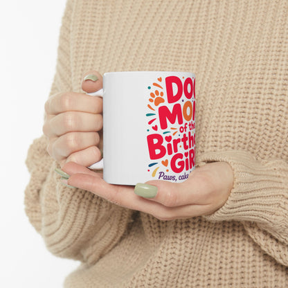 White mug held by hands, "Dog of the Birthday Girl" text with paw prints.