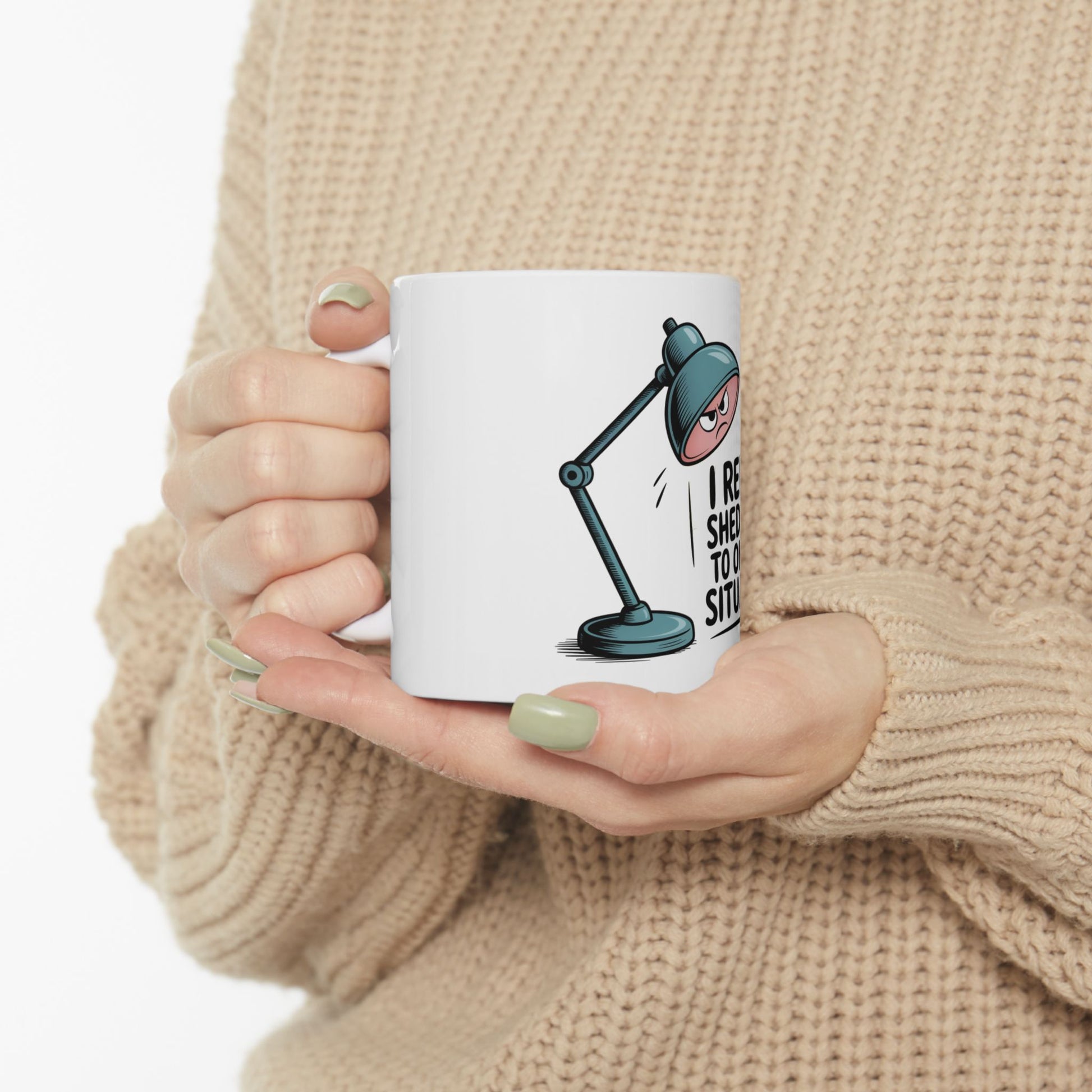 White mug with a cartoon desk lamp graphic and text.