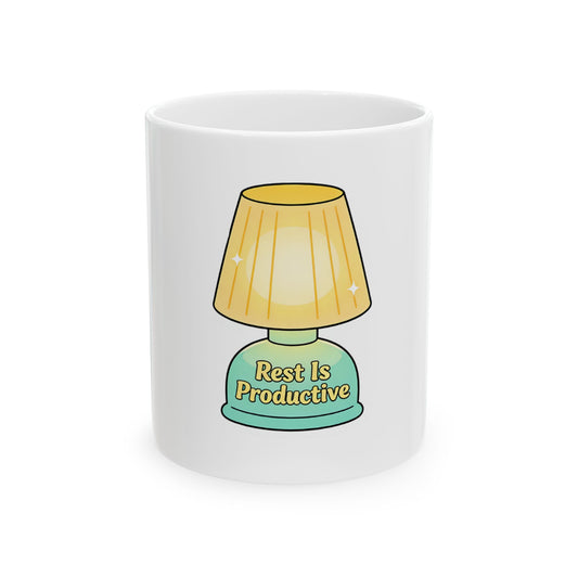White mug with a cartoon lamp illustration and text that says "Rest Is Productive".