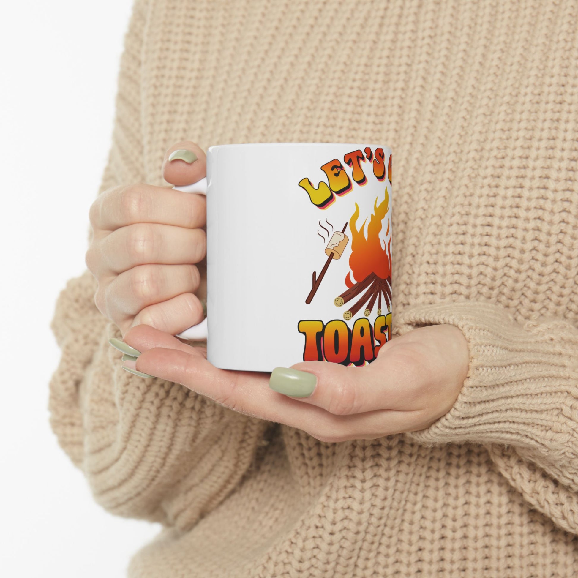 Mug with "Let's Toast" and a marshmallow on a stick over flames.