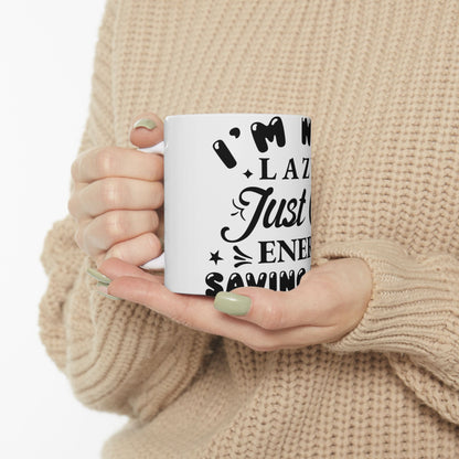 White mug with "I'm Not Lazy Just Saving Energy" text held by hands.