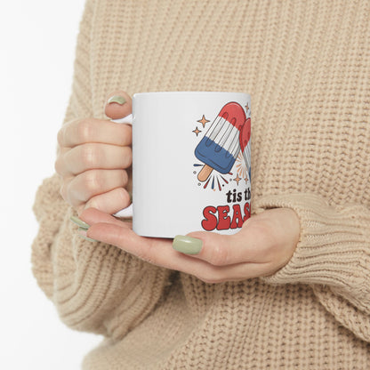 White mug with "tis the season" and popsicle art.
