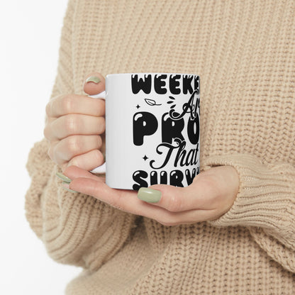 White mug with "WEEKEND PRO SURVIVOR" text held by hands.