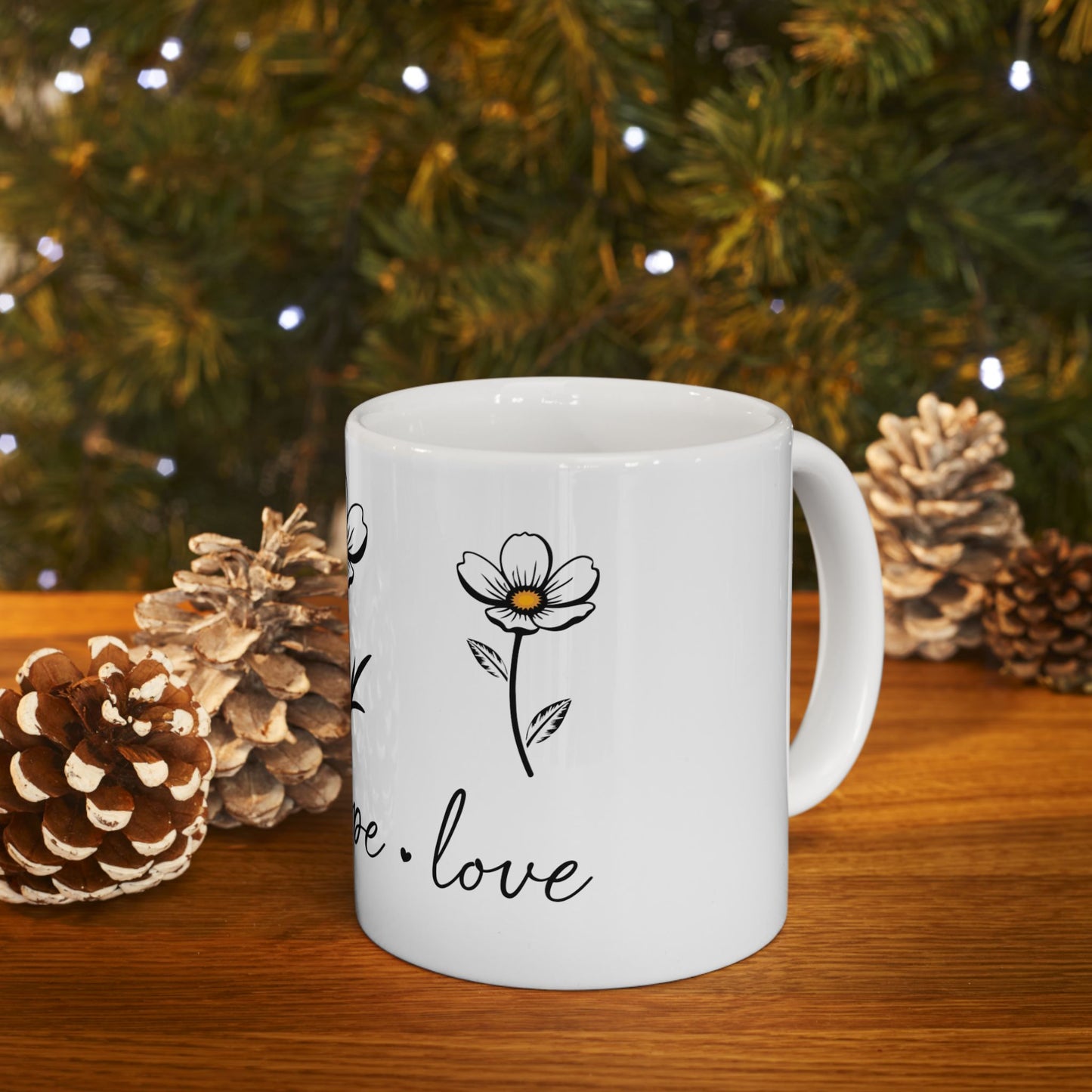 White mug with floral design and text "hope. love" on wooden surface.