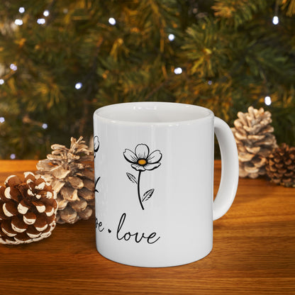 White mug with floral design and text "hope. love" on wooden surface.