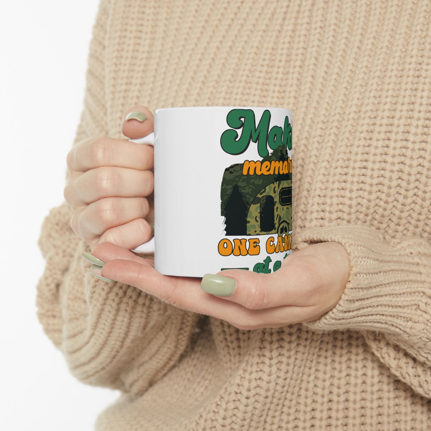 White mug with green text "Make memories one camp at a time" and a camouflage camper.