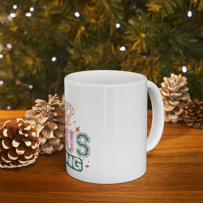 White mug with "TIS THE SEASONING" text on wooden surface, festive background.