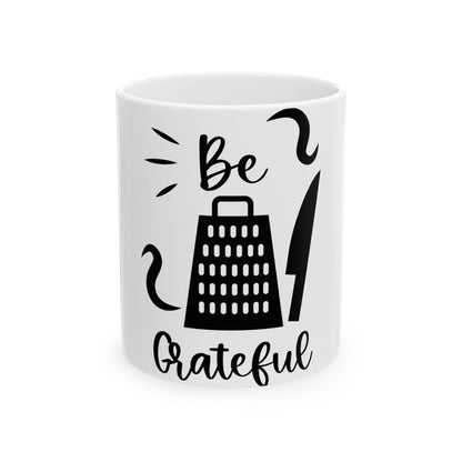 White mug with "Be Grateful" and grater and knife graphics.