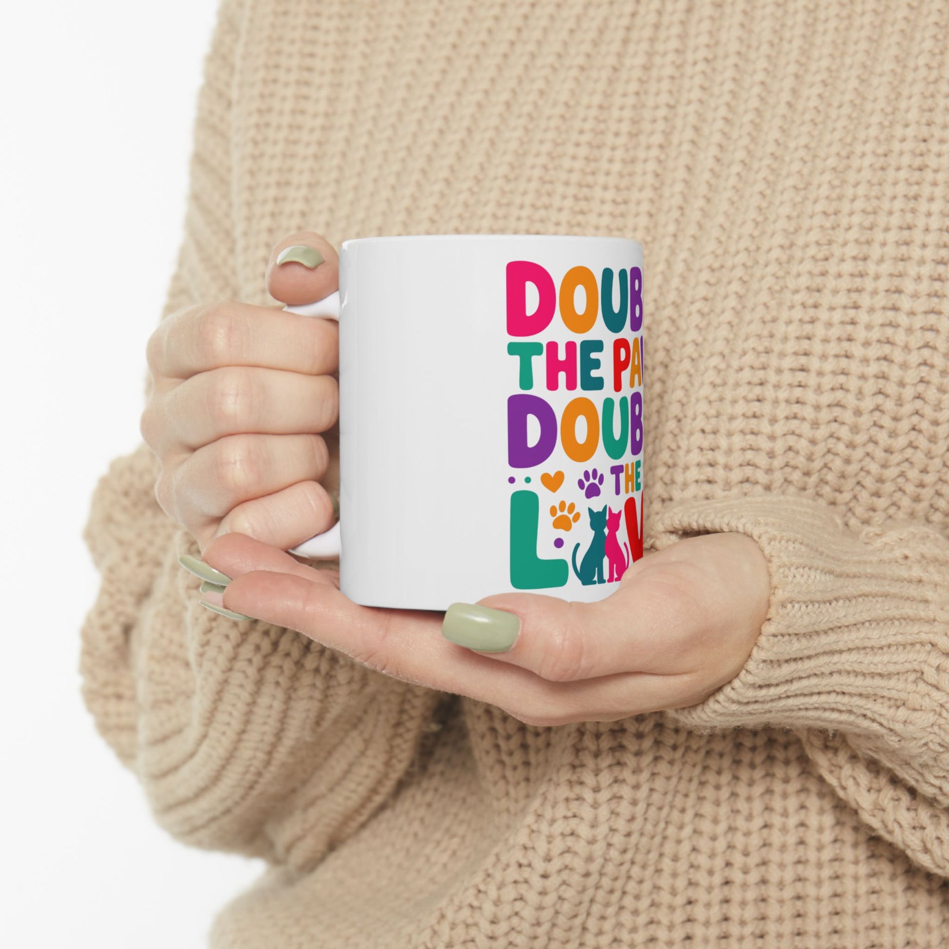 White mug with colorful text "DOUB THE PA THE LO" and a cat silhouette.