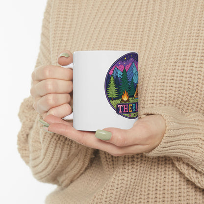 White mug with "THERAPY" text and mountain scene design.
