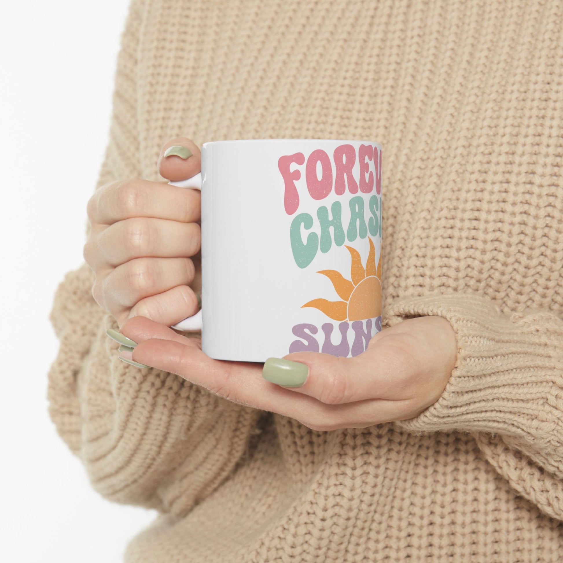 White mug with colorful text "FOREVER CHASING SUN" held by person.