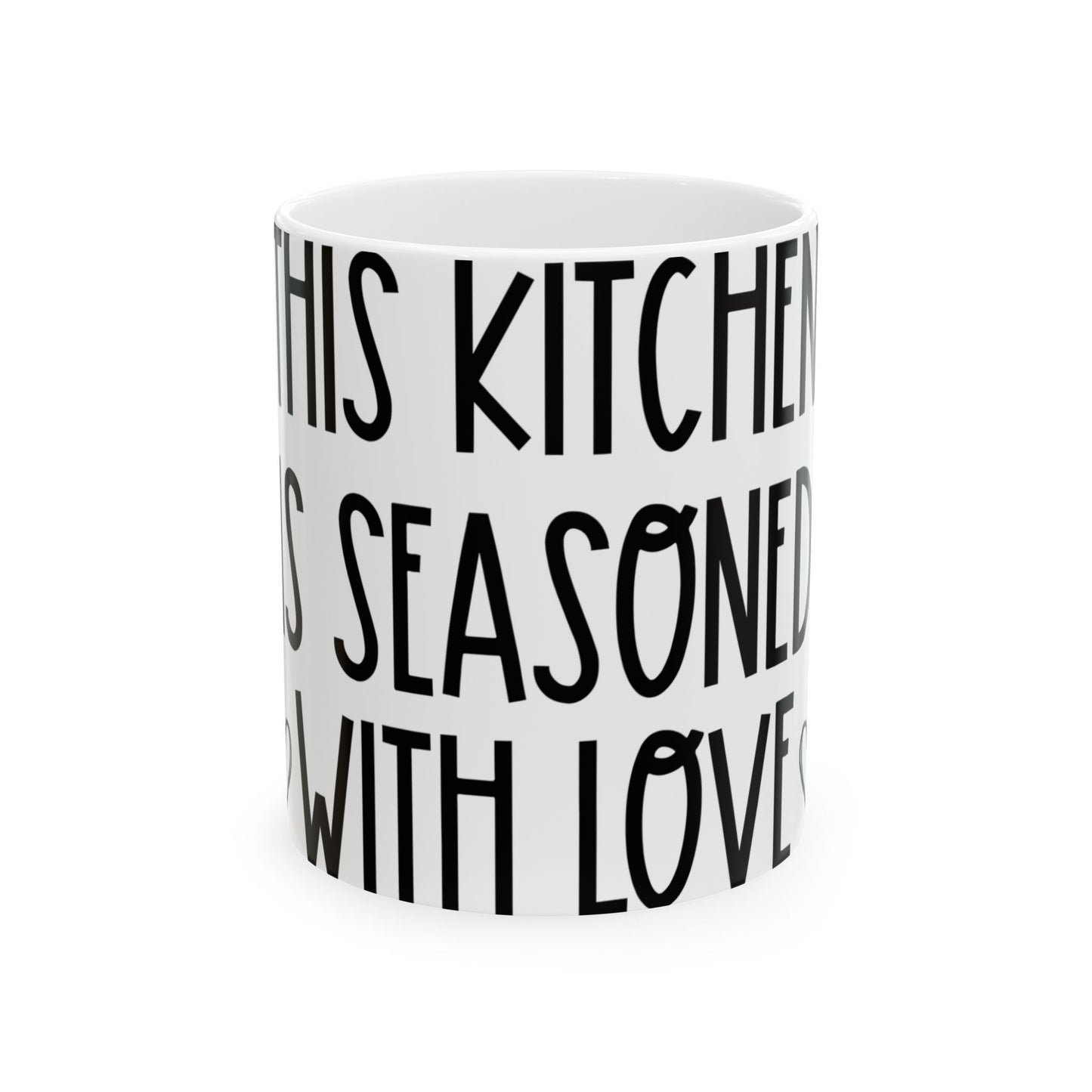 White mug with black text reading "IN THIS KITCHEN IS SEASONED WITH LOVE".