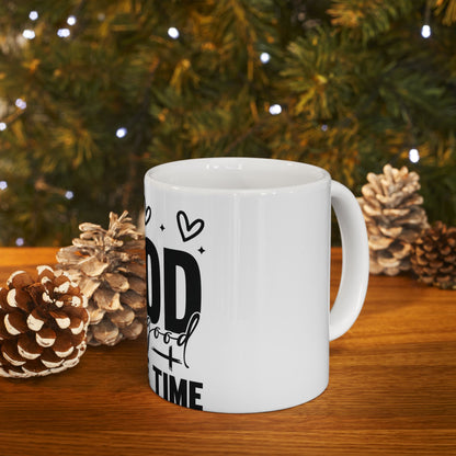 White mug with "Good Times" text, set against pinecones and blurred green garland.