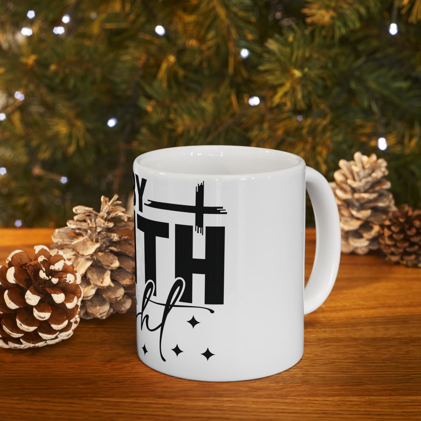 White mug with "faith" text, pinecones, and Christmas lights background.
