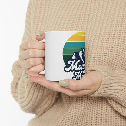 White mug with mountain graphic and retro sunset design.