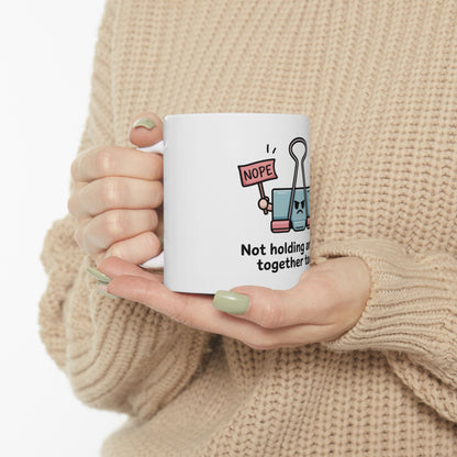 Binder clip with "Nope" sign holding together text on a white mug.