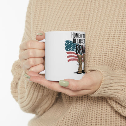 White mug with "HOME OF THE BRAVE BECAUSE OF THEM" and American flag boots.
