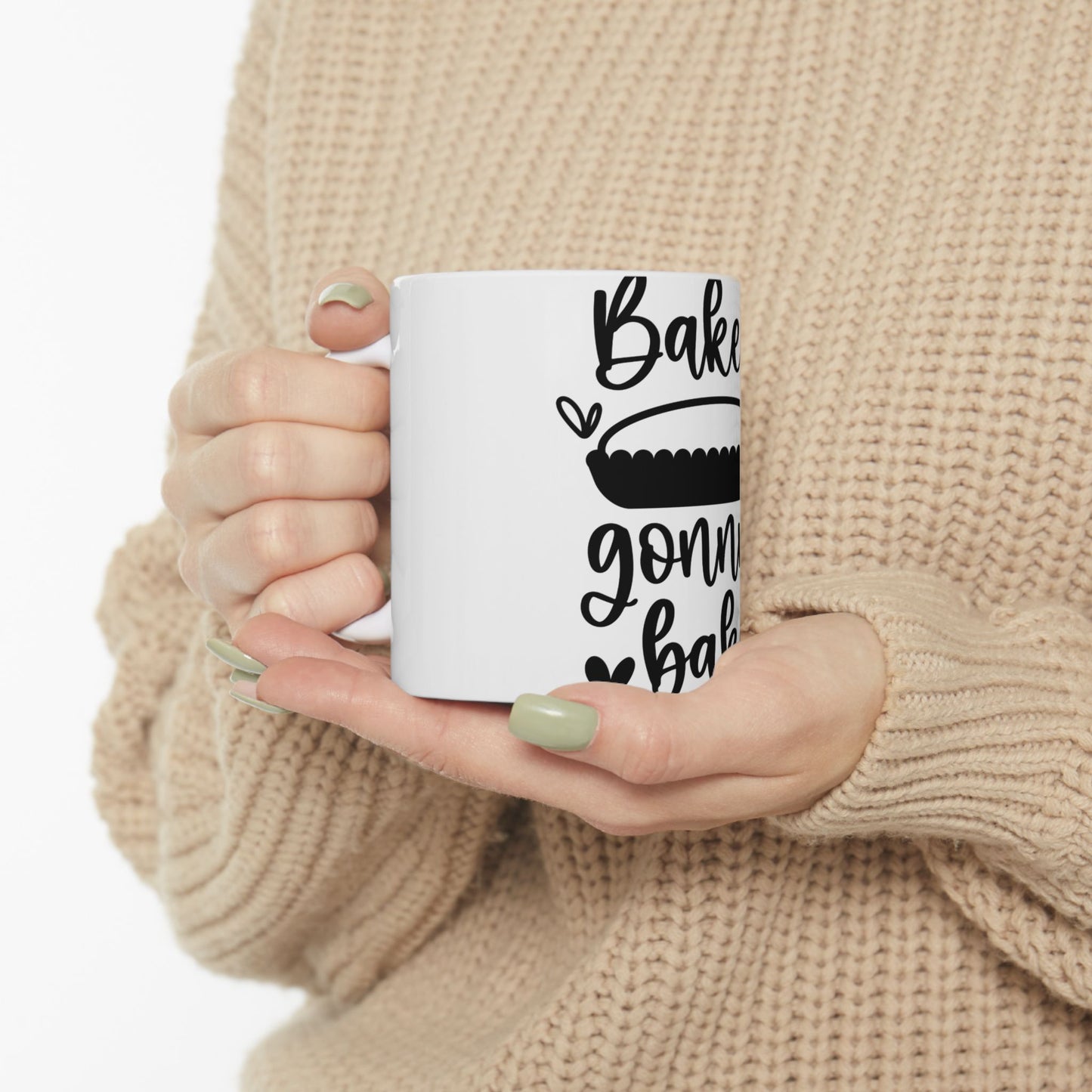 White mug with "Bake" and pie graphic held by hands.