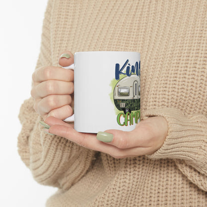 White mug with "Kindred Camper" text and a cartoon RV on it.