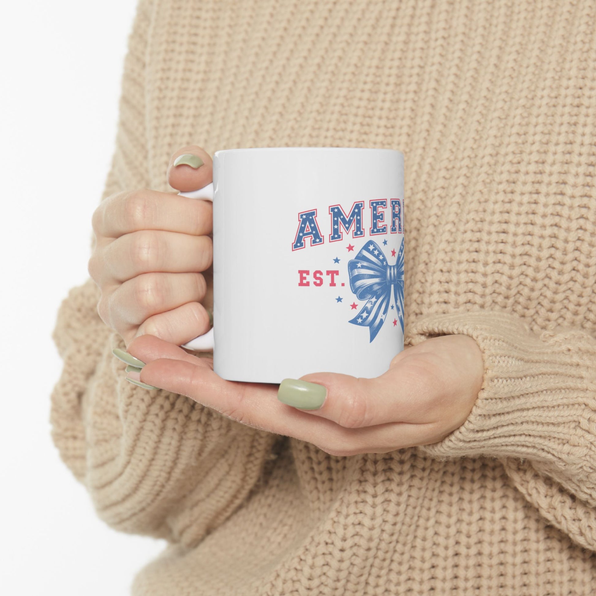 White mug with "AMER EST." and a red, white, and blue bow graphic.