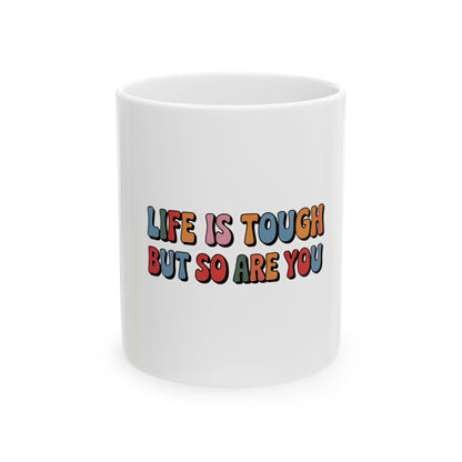 White mug with "Life is tough but so are you" in colorful retro text.
