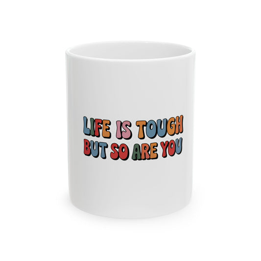 White mug with "Life is tough but so are you" in colorful retro text.