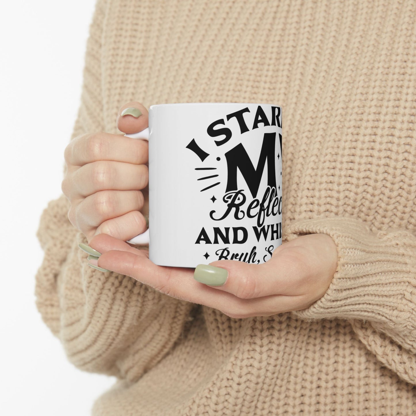 Mug with "I STAR Reflec and WHI Brwh, S" text held by hands in beige sweater.