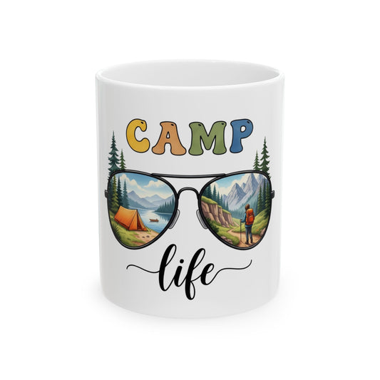 Mug with "CAMP life" text and sunglasses reflecting a mountain landscape.