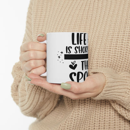 White mug with "LIFE IS SHORT THE SPO" text and decorative dots.