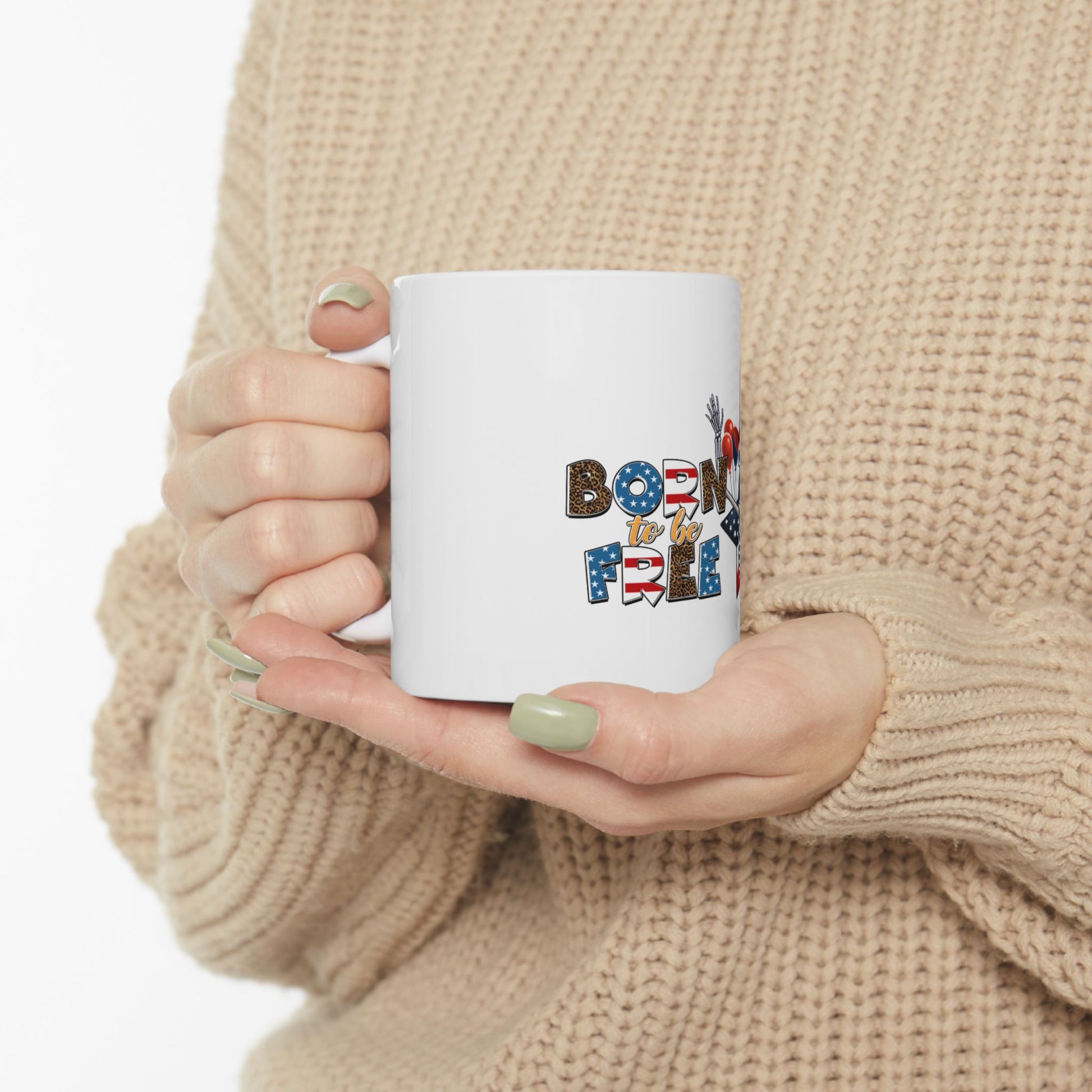 White mug with "Born to be Free" text and American flag elements.